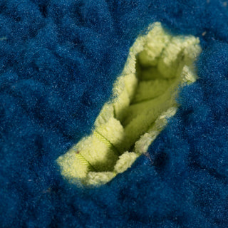 Close-up of the treat-trapper ball, showing one of the three green holes designed to hide treats inside for your dog to discover.