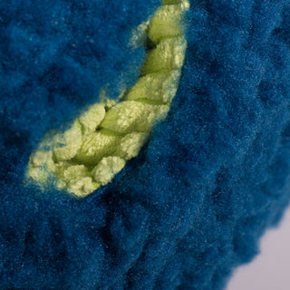 Close-up of the treat-trapper ball, showing one of the three green holes designed to hide treats inside for your dog to discover.
