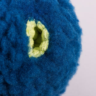 Close-up of the treat-trapper ball, showing one of the three green holes designed to hide treats inside for your dog to discover.
