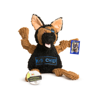 Photo of a black and tan German Shepherd dog toy.  He has an eye patch over his left eye.  On his belly his name, K-9 Chief, is embroidered.  This picture also includes the hang tags that are attached to to toy.  He has two; one is a branded HuggleHounds tag and the other is a special card that has the real life Chief pictured on it. 