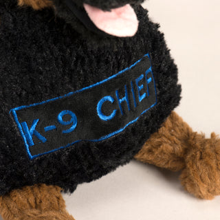 This is a closeup photo of the embroidery on the dog toy's belly of the name, K-9 Chief.  The embroidery is done using a bright blue thread.