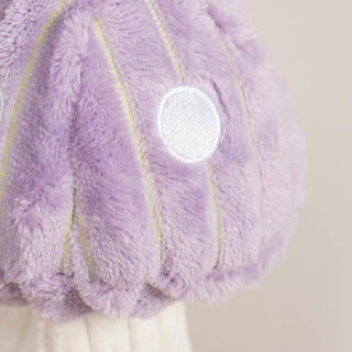 Close up view of lavender mushroom with white polka dots. 