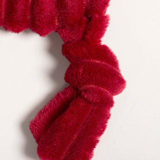 Knotted limbs of St. Nick HuggleFlattie showing plush red corduroy fabric.
