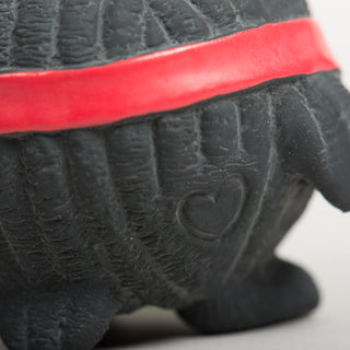 Embossed heart detail on the back of the black Ruff-Tex® penguin dog toy with red scarf.
