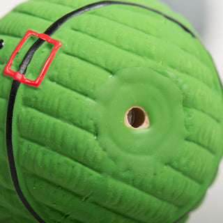 Close-up of a green Ruff-Tex® holiday dog toy showing squeaker hole and black belt detail.

