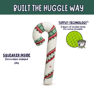 A holiday-themed dog toy shaped like a candy cane, featuring a white ribbed body with red and green patterned stripes. The image includes marketing text and a circular inset showing the green TUFFUT technology lining.