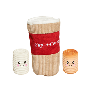 Three plush cup-shaped toys with smiling faces on a white background: a large beige corduroy cup with a red band reading 'Pup-a-Cocoa' in the center, and two smaller beige and peach plush cups on either side.