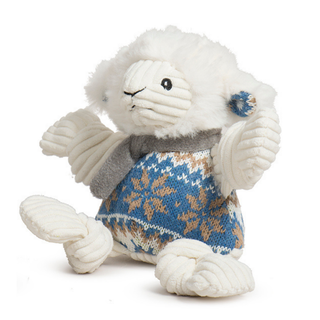 A white plush lamb toy wearing a gray knit scarf and a blue, tan, and white patterned sweater, photographed on a clean white background.