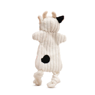 Back view of white cow plush dog toy with black spot on back, one black ear, and beige horns and inner ears.