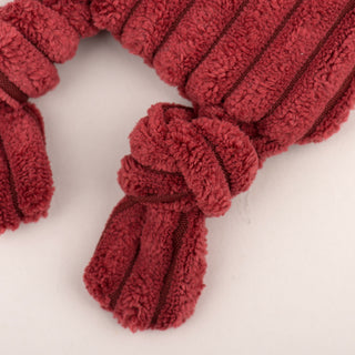 Close up of knotted leg on maroon fox plush dog toy.