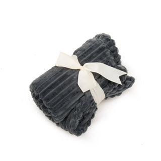 Charcoal colored scout blanket rolled up and wrapped with a white ribbon. 