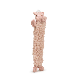 Side view of elongated pig plush dog toy with dusty pink colored HuggleFleece® body, white hair tuft on top of head, dusty pink corduroy face, ears, arms, and legs, and brown embroidered nose and closed eyes.