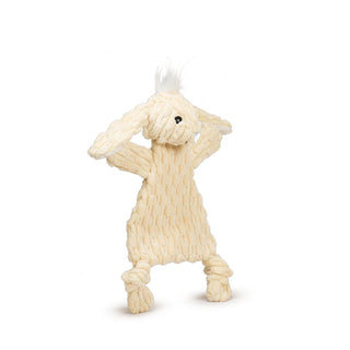 Side view of pale yellow triangle shaped bunny corduroy plush dog toy with long ears, white corduroy inner ears, white hair tuft on head, knotted legs, short stubby arms, and black embroidered eyes and nose.