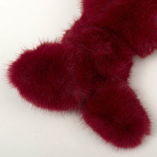 Close up of knotted tail on Noel Narwhal to show texture of maroon faux-fur.