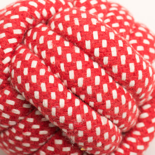 Close up of red and white knotted rope ball to show texture.