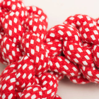 Close up of red and white knotted rope bone to show texture.