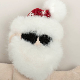 Close up of Santa plush dog toy to show texture of fluffy white beard and black sunglasses.