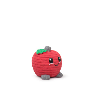 Side view of red apple-shaped latex squeaky ball dog toy in small with red corduroy texture, gray stem and feet, green leaf next to stem, big black eyes, cute black smile, and cute pink cheeks.