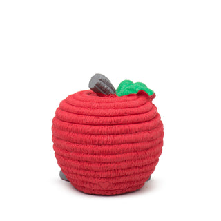 Back view of red apple-shaped latex squeaky ball dog toy in small with red corduroy texture, gray stem and feet, and green leaf next to stem.