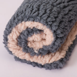 Image of dusty rose and gray colored mat rolled up to show two tones.