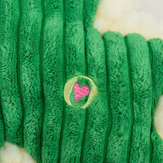 Close up image of HuggleGroup logo on green shamrock durable plush dog toy. 