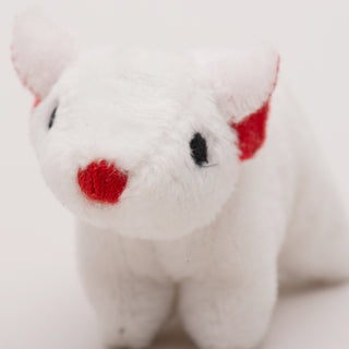 Close up view of mouse shaped, catnip stuffed cat toy face: has white fur, black eyes, red nose, and red inner-ear.