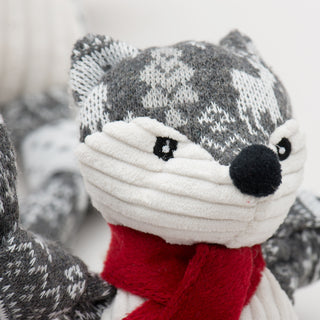 Festive fox shaped durable plush dog toy: fur has a gray and white Christmas sweater pattern, black nose, black eyes, white pupils, has a white face. 