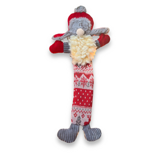 Christmas themed Santa with a trapper hat durable plush dog toy: long, flat, stuffing-less body with red and tan nordic fabric, grey corduroy sleeves and shoes, red gloves, natural colored HuggleFleece® beard, red trapper hat with fluffy gray accents, and only the nose showing from underneath the hat.