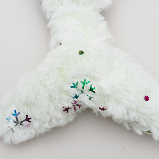 Close up of knotted tail of narwhal plush dog toy.