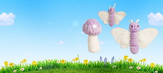 Desktop banner with blue sky, white clouds, green grass and flowers. With a set of 2 purple butterfly dog toys with white wings and a purple and white polka dot mushroom with a white stem .