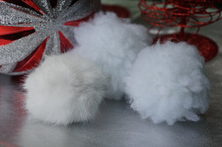 Lifestyle of three white plush snowball cat toys.