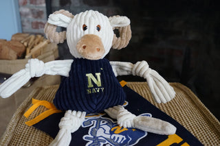 U.S. Naval Academy Bill the Goat durable plush corduroy dog toy sitting on Navy pennant.