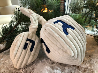Set of two Dreidel shaped plush dog toy: has white knotted top, with the Hebrew scripts on each of the four sides embroidered in blue.