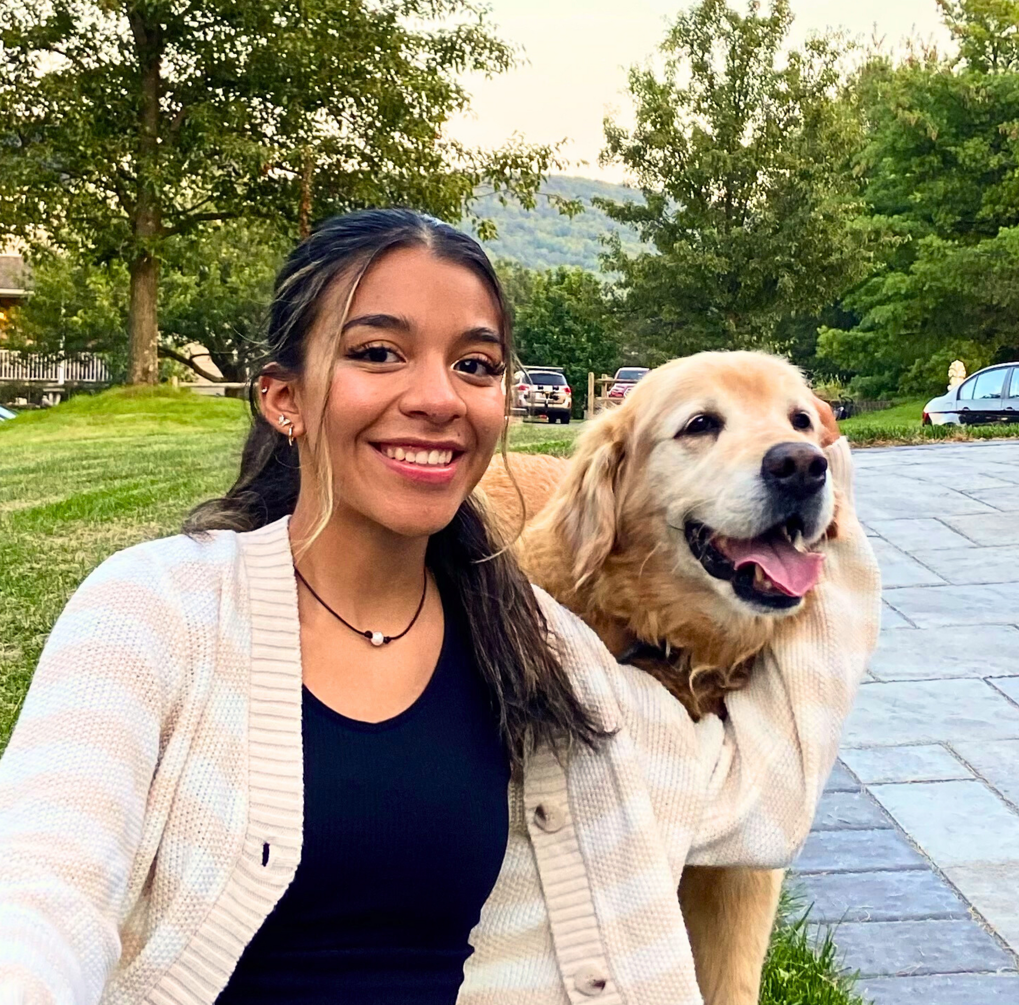 A women smiling next to a happy dog.