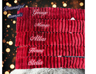 Stack of red and white dog scaves with different name embroidered to show the look of the scarf personalization.