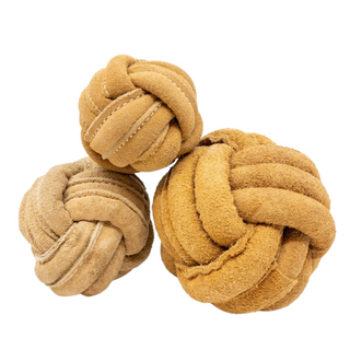 Three tan natural leather knotted ball dog toys in small, medium, and large stacked.