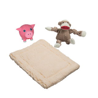 Small brown and white sock monkey durable corduroy plush dog toy with knotted limbs and small pink pig squeaky latex ball dog toy sitting on a natural cream colored HuggleFleece® dog mat.