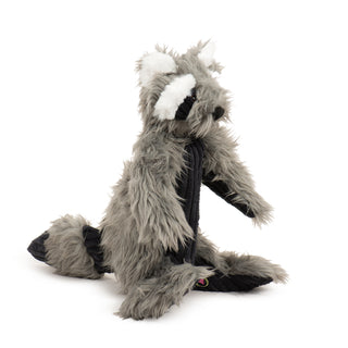 Side view of raccoon plush dog toy with dark gray faux-fur, black corduroy stomach and around eyes, white fluffy and bushy eyebrows and inner ears, black nose, striped tail with black corduroy and dark gray faux-fur, and brown and black embroidered eyes.