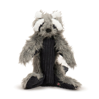 Raccoon plush dog toy with dark gray faux-fur, black corduroy stomach and around eyes, white fluffy and bushy eyebrows and inner ears, black nose, and brown and black embroidered eyes.