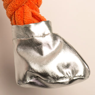 Silver metallic bag with orange yarn on a beige background