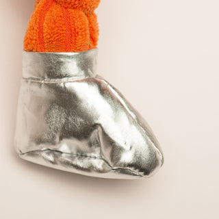 Metallic shoe with orange sock on a beige background