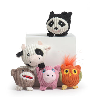 Five tiny ball shaped plush corduroy toys with little legs designed for toy-sized dogs. Includes a black and white cow, black and white raccoon, brown and white sock monkey, pink pig with blue eyes and orange and lime green owl with yellow eyes.