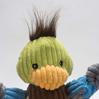 Close up of duck shaped durable plush corduroy dog toy with brown fur on the top of the head, light green face, black eyes, and yellow bill.