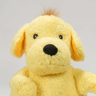 Close view of dog shaped plush dog toy face: has golden-yellow fur, brown hair, two floppy ears, brown eyes, white pupils, golden-yellow plush-out, with a black nose. 