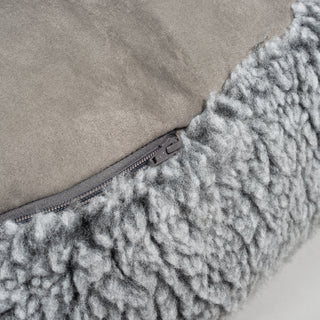 Close up view of zipper on charcoal colored fluffy bed. 