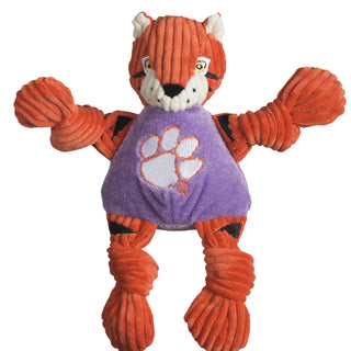 Clemson University the Tiger durable plush corduroy dog toy with knotted limbs, orange fur with black tiger stripes, white inner-ear, white outer-eye with yellow eyes and white pupils, black nose, white mouth, and is wearing a purple shirt with the university logo on the chest. Size small.