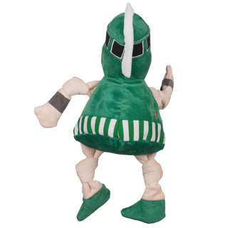 Back view of Michigan State University Sparty mascot plush dog toy with beige skin tone face and knotted limbs, green warrior helmet with black and gray details and white ornamental hackle, grey wrist bands, green shirt with white and green striped band around waist, and green shoes.