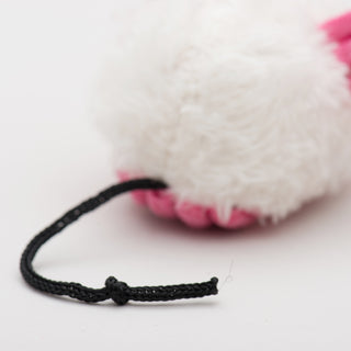 Close up of black string tail of pink dust bunny.