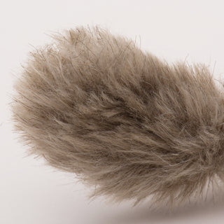 Close up image of fluffy tail on light-brown furred squirrel cat toy. 