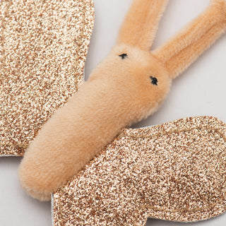Close up image of butterfly shaped catnip stuffed cat toy: butterfly is beige, stuffed with catnip, has beige knotted antennas, and sparkly, crinkly wings.